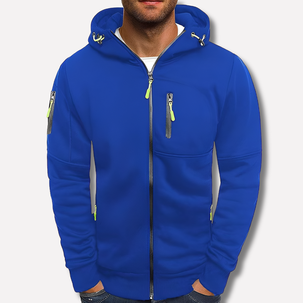 Modrá mikina na zip s kapucí na muži před světlým pozadím, detail zipové kapsy na hrudi a na rukávu. 2