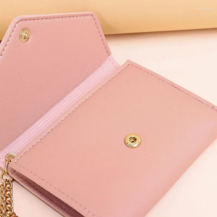 Rosa Mini-Geldbörse mit Quastenanhänger, Lederoptik, goldener Kettenverschluss, Damenaccessoire.