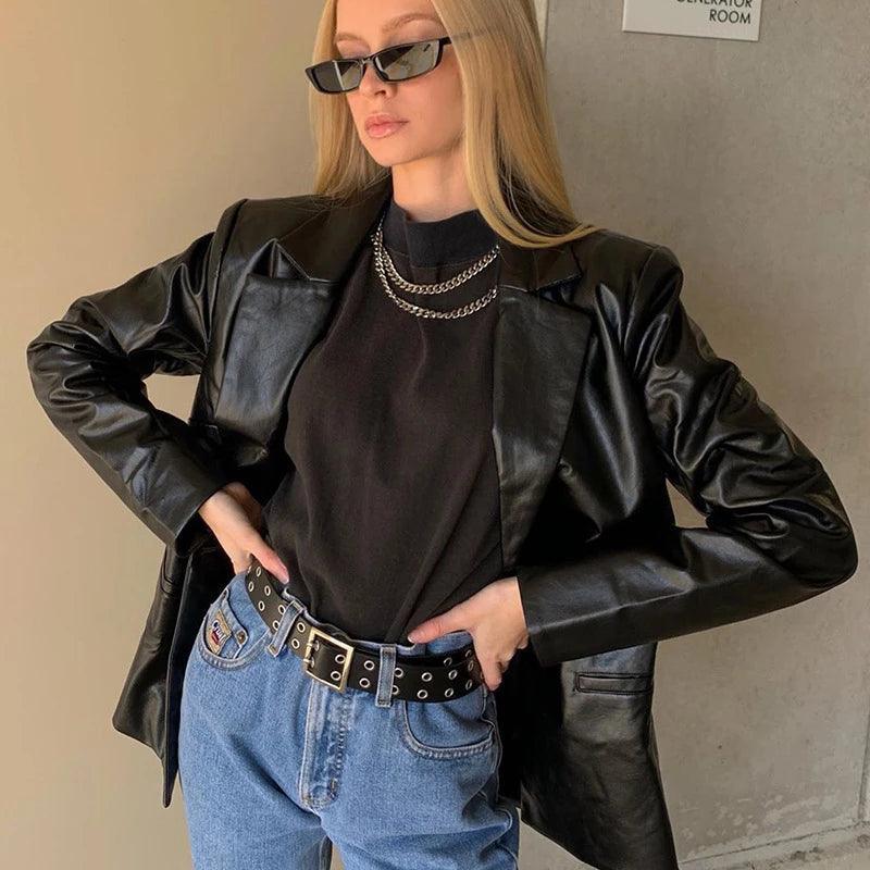 Frau in schwarzer Lederjacke, Sonnenbrille, Jeans; modischer Herbstlook für Damen.