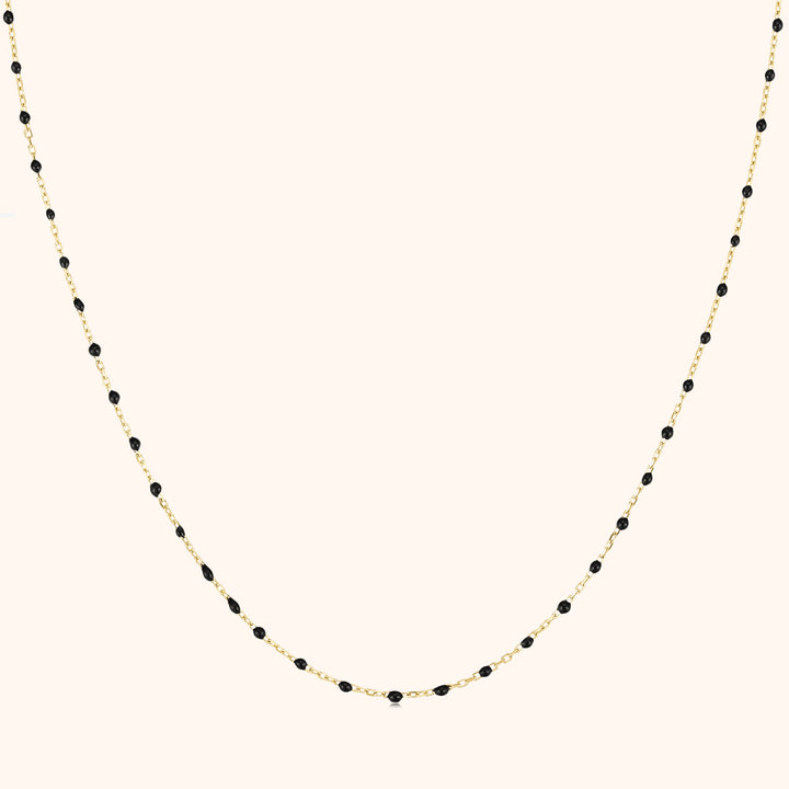 Goldene Halskette mit schwarzen Perlen, elegantes Schmuckdesign, Damenaccessoire.