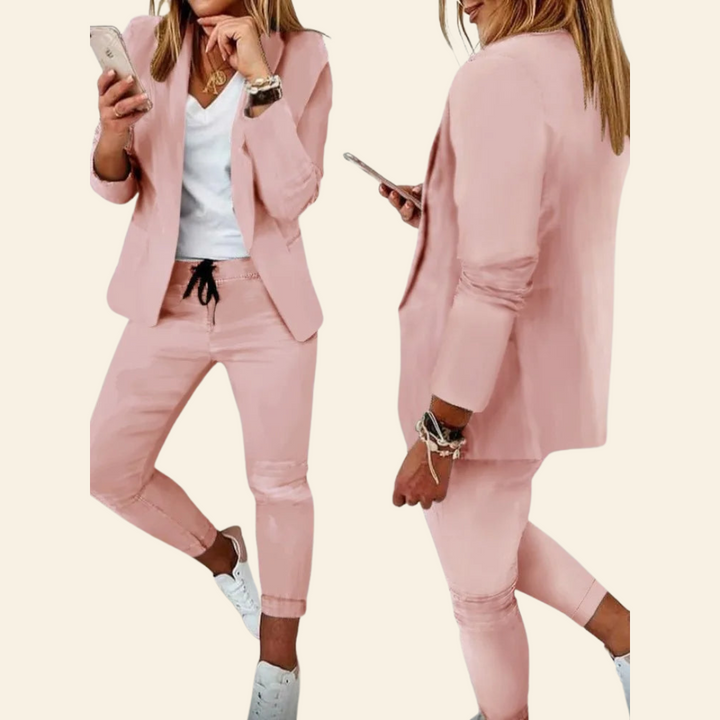 Frau in rosa Anzug mit Smartphone, weißem T-Shirt und Sneakers, modisch, Business-Look.