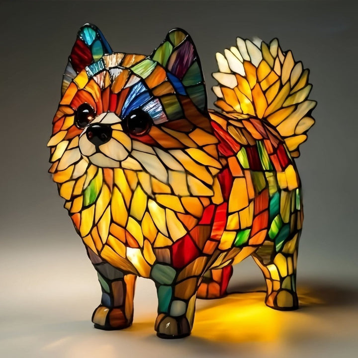 Stojící lampa ve tvaru špice s načechraným ocasem a oranžově žlutými vitrážovými dílky, svítící na šedém pozadí. 18
