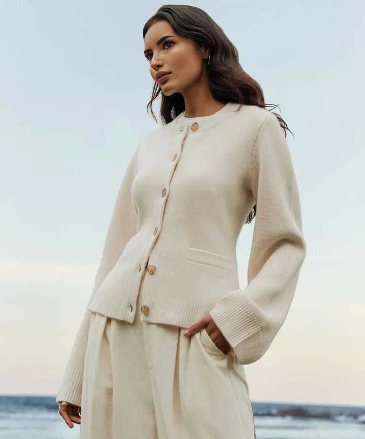 Frau in cremefarbenem Button-Up-Strickpullover am Strand, elegantes Design, Herbstmode.