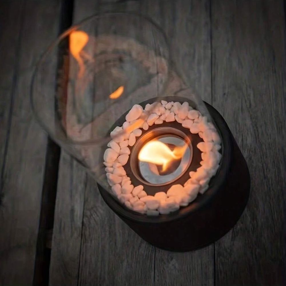 Tischfeuer mit Glaszylinder, Kieselsteinen, Flamme, dekorative Beleuchtung, modern, schwarz.
