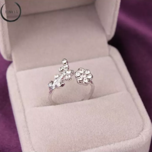 Silberner Damenring mit Blumenmuster und Strasssteinen in Schmuckschatulle.