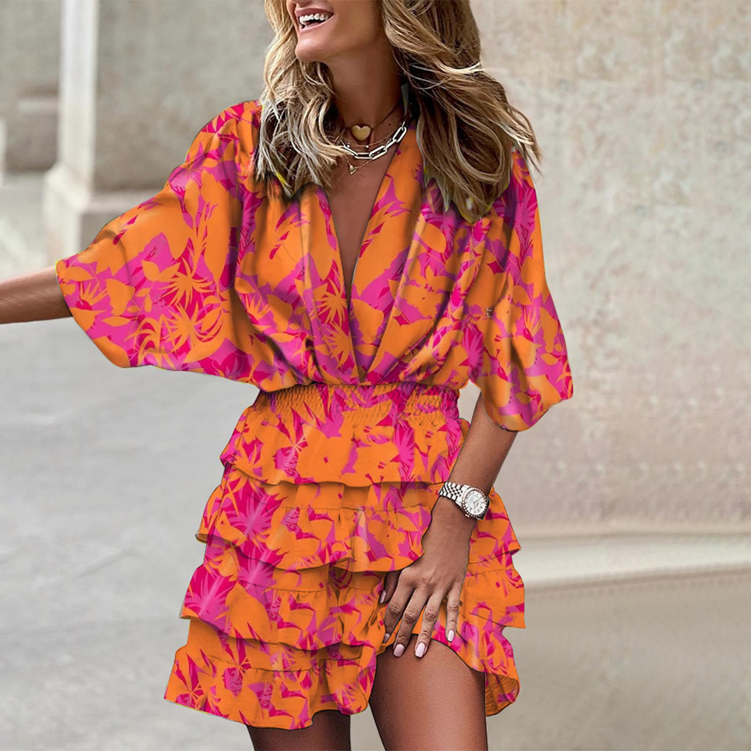 Frau in orange-pinkem Blumenkleid, Rüschen, lächelnd, modisch, Sommermode, draußen.