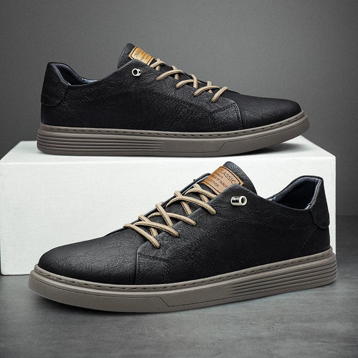 Schwarze Oxford-Ledersneaker, bequem, atmungsaktiv, mit braunen Schnürsenkeln.