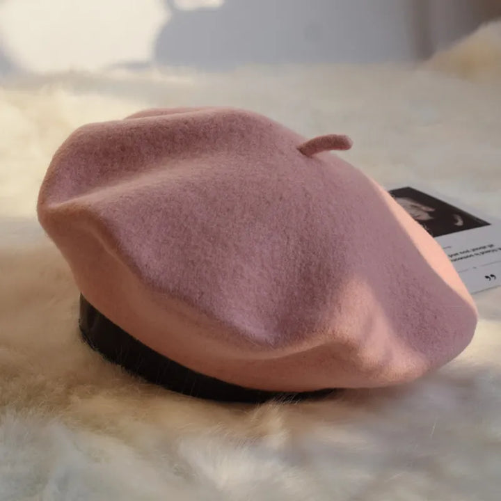 Rosa Woll-Baskenmütze auf weißem Hintergrund, modisches Accessoire für Damen.