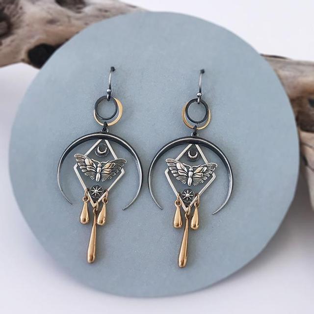 Silberne und goldene geometrische Ohrringe mit Schmetterlingsdesign, Vintage-Stil.