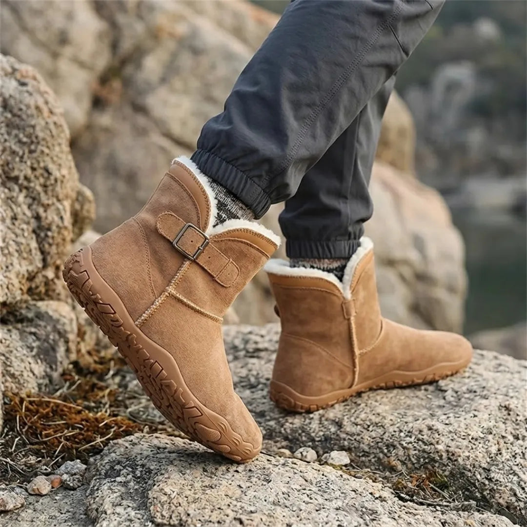 Hnědé barefoot boty s bílou huňatou podšívkou na nohou chodce na skalnatém terénu 20