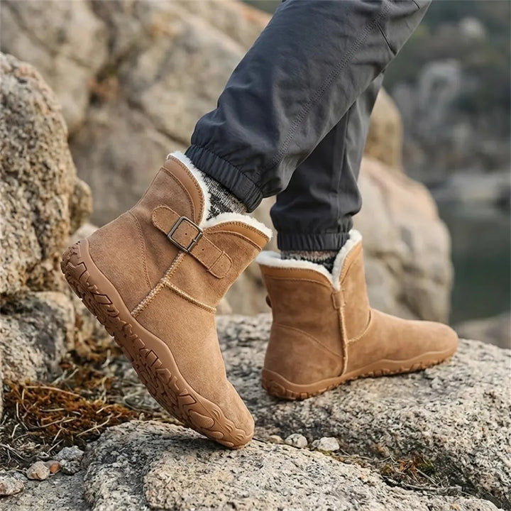 Hnědé barefoot boty s bílou huňatou podšívkou na nohou chodce na skalnatém terénu 20