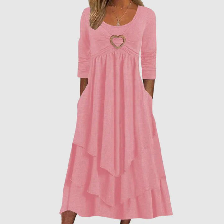 Rosa Damenkleid mit Herzanhänger, dreiviertel Ärmel, Stufenrock, elegantes Design.