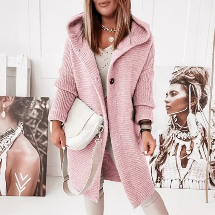 Frau in rosa Strickmantel mit Kapuze, weiße Tasche, modisch, lässig, Herbstmode.