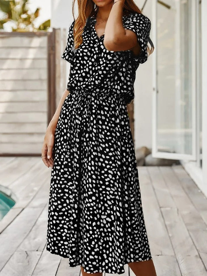 Frau in schwarz-weiß gepunktetem Sommerkleid auf Terrasse, Freizeitmode, Damenbekleidung.