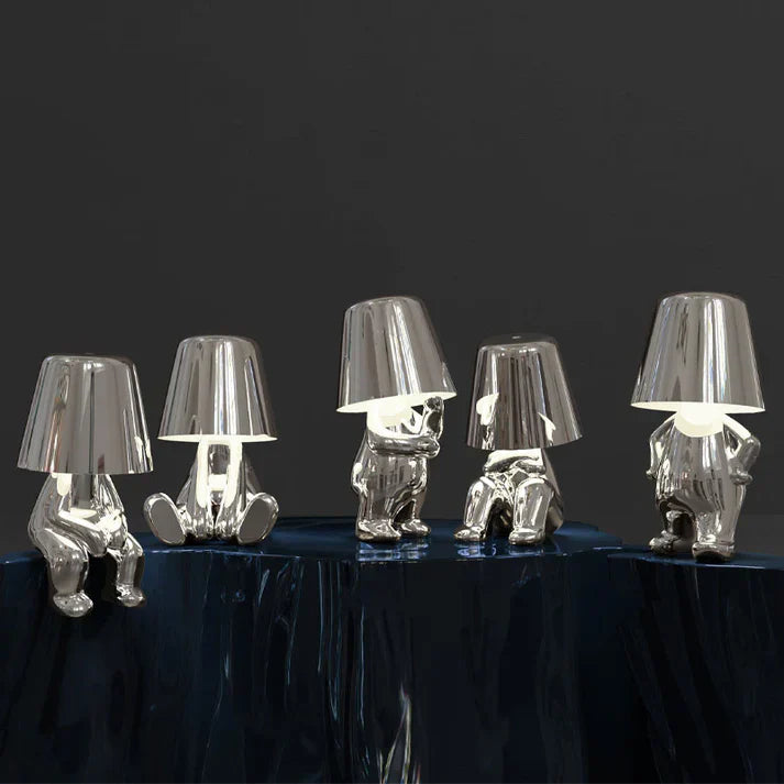 Fünf silberne Tischlampen in menschlicher Form auf dunklem Hintergrund, modernes Design.