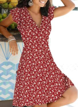 Frau in rotem Sommerkleid mit Blumenmuster, V-Ausschnitt, kurze Ärmel, lächelnd.