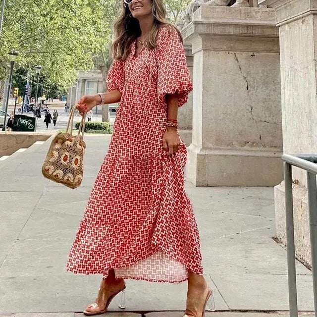 Frau in rotem Maxikleid mit Muster, Strohtasche, Sandalen, Sommermode, Stadtstraße.