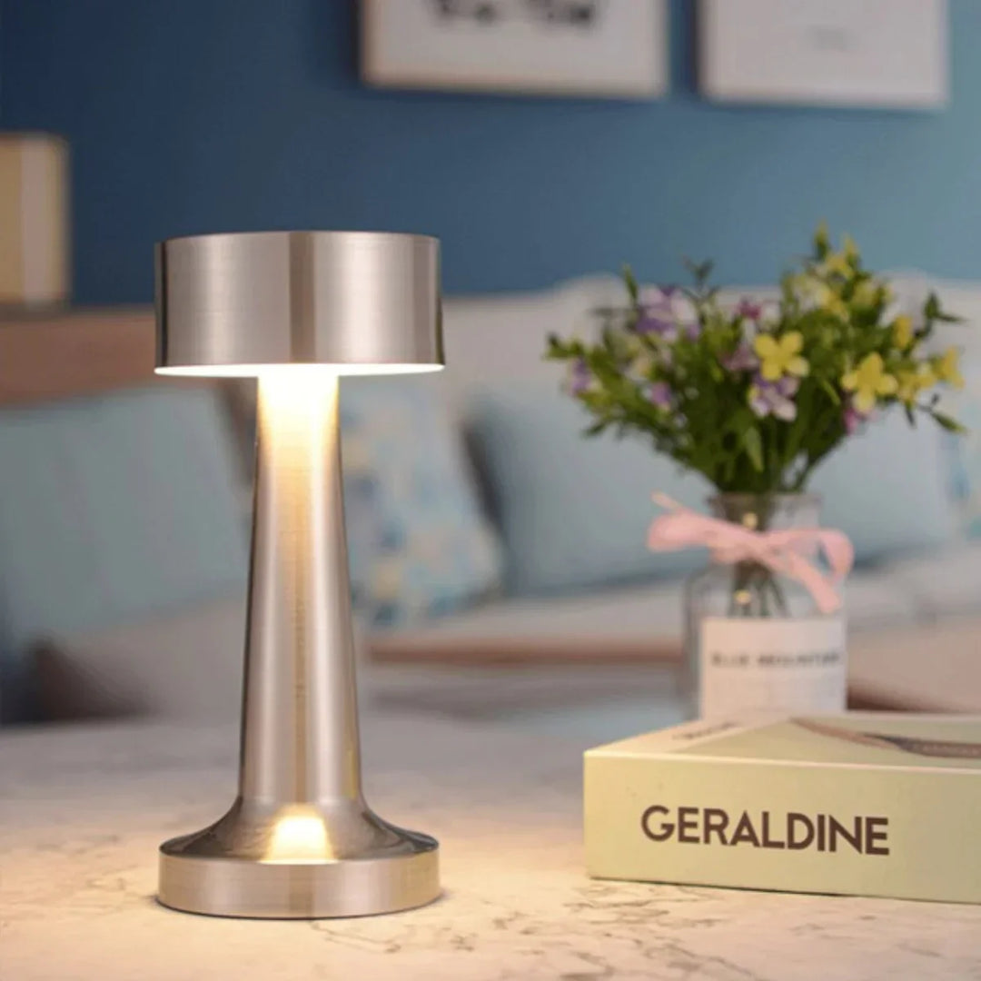 Moderne silberne Tischlampe aus Metall auf Marmortisch im Restaurant, LED-Beleuchtung, stilvoll.