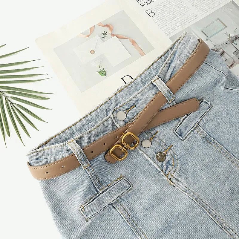 Damen Retro Gürtel, braun, mit Schnalle, auf blauer Jeans, modisches Accessoire, Lederoptik.