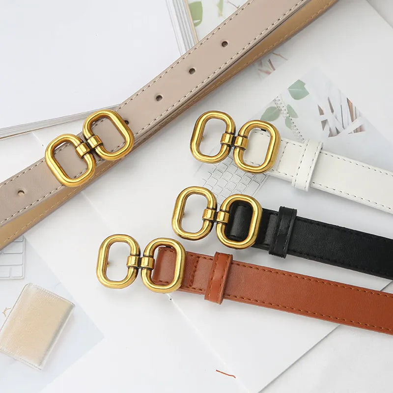 Vier Retro-Gürtel mit goldener Schnalle in Beige, Weiß, Schwarz und Braun auf hellem Hintergrund.