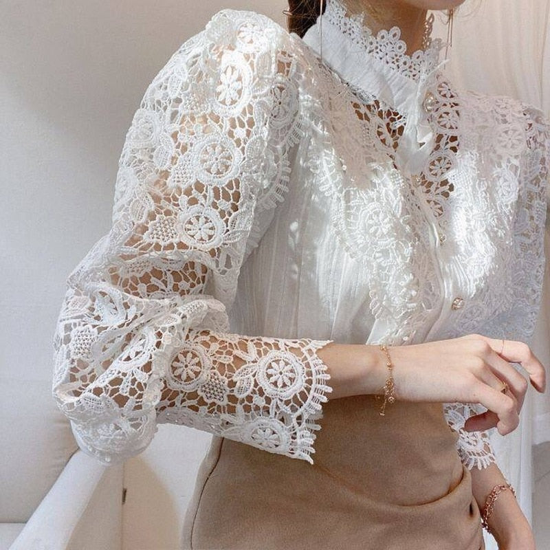 Damenbluse aus weißer Spitze, elegantes Design, langärmlig, ideal für formelle Anlässe.