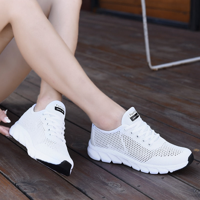Weiße Damen-Sneaker aus Mesh, atmungsaktiv, sportlich, auf Holzterrasse.