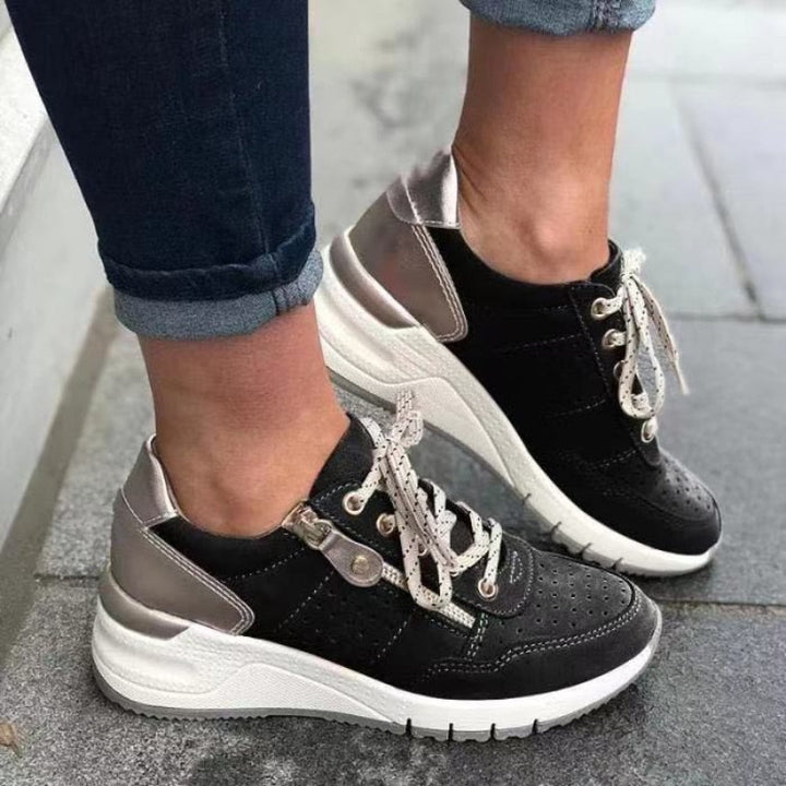 Schwarze Damen-Sneaker mit weißer Sohle und silbernen Akzenten, sportlich, modern, bequem.