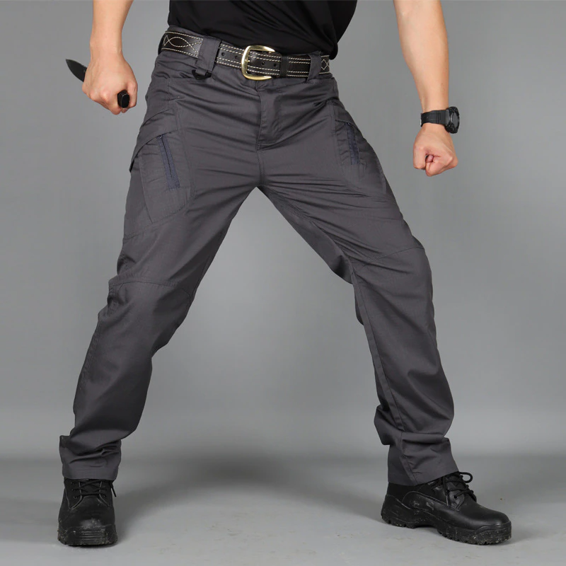 Mann in taktischer Hose, schwarz, mit Messer, Outdoor-Ausrüstung, robust, strapazierfähig.