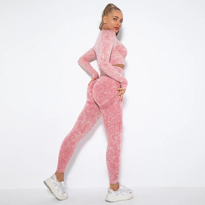 Frau in rosa nahtlosem Sport-Set, langärmeliges Oberteil, Leggings, weiße Sneaker, Fitnessmode.