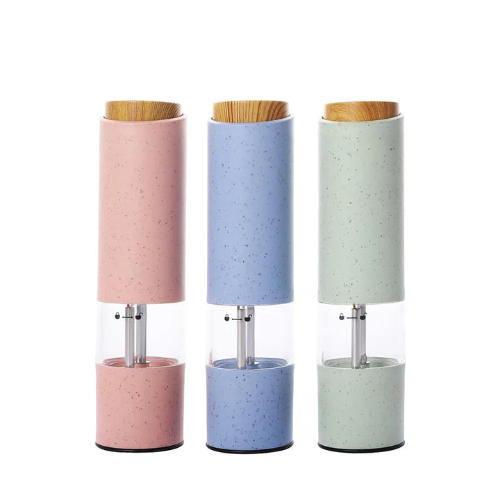 Drei elektrische Salz- und Pfeffermühlen in Rosa, Blau und Grün mit Holzdeckel.