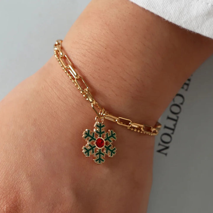 Goldenes Armband mit grünem Schneeflocken-Anhänger, roter Edelstein, modisches Schmuckstück.