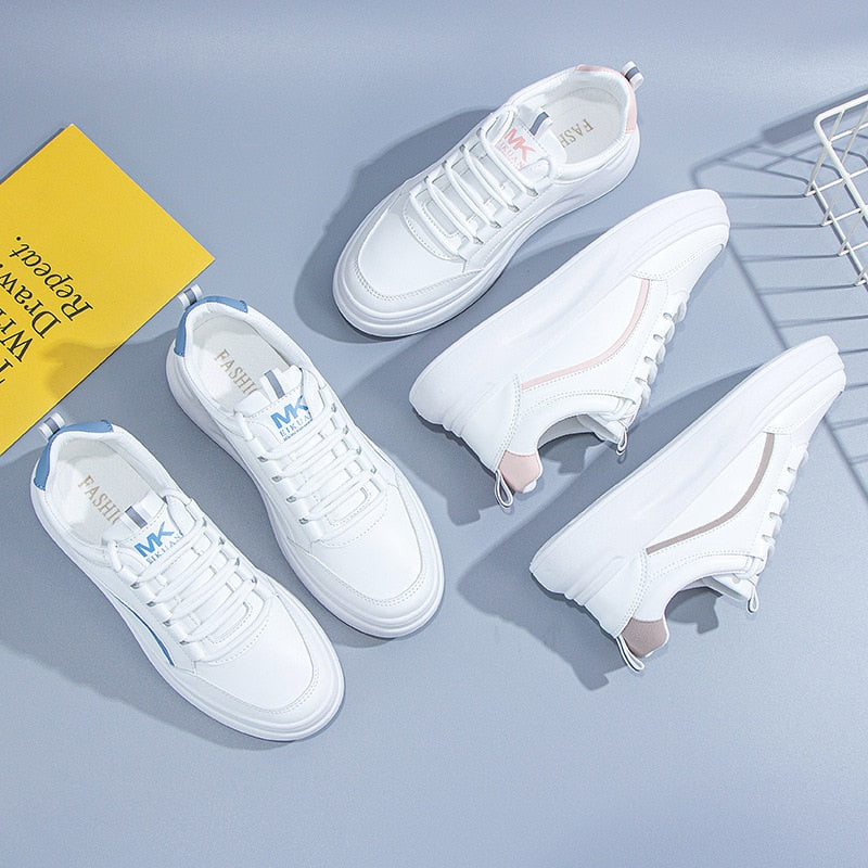 Weiße Sneaker für Damen, Leder, modisch, bequem, mit blauen und rosa Akzenten.