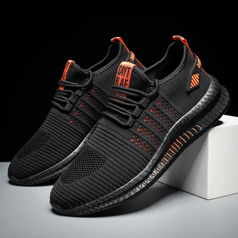 Schwarze Sportschuhe mit orangen Akzenten, atmungsaktives Mesh, rutschfeste Sohle, Herren Sneaker.