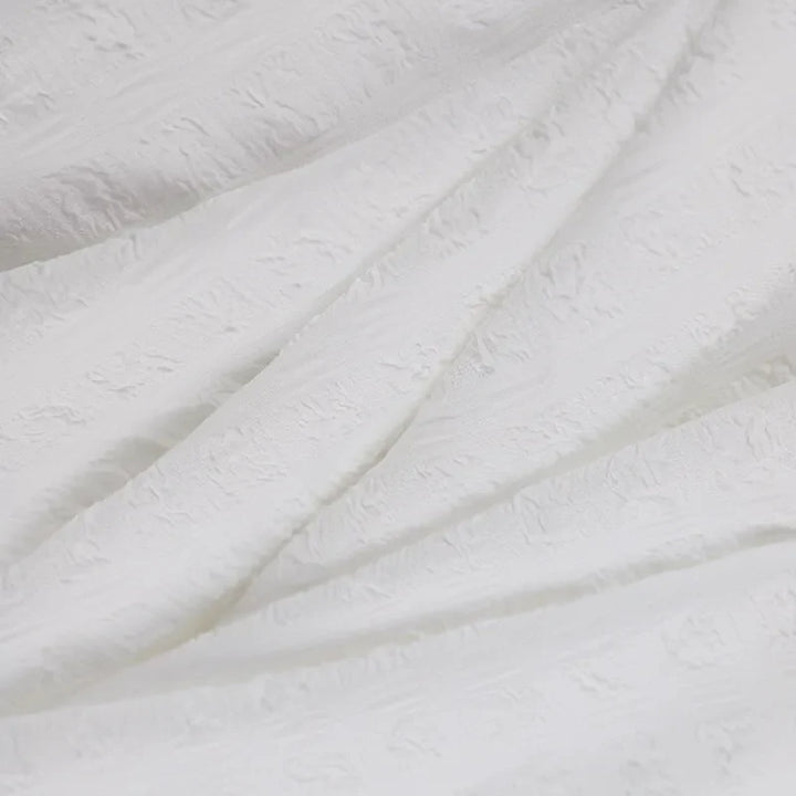 Weiße Jacquard-Stoffstruktur, elegant, hochwertig, ideal für Mode- und Inneneinrichtung.