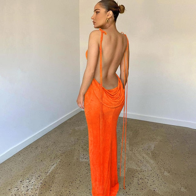 Frau in orangefarbenem, rückenfreiem Abendkleid, elegantes Design, modisch, minimalistischer Raum.