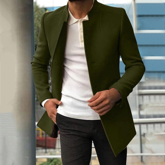 Mann in olivgrünem Mantel, weißem Pullover, grauer Hose, moderne Herrenmode, urbaner Stil.
