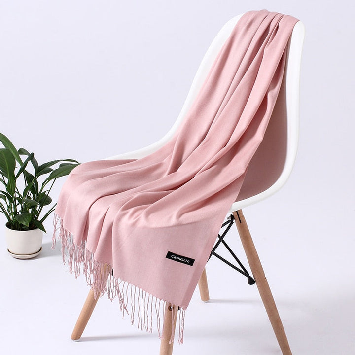 Rosa Kaschmirschal auf Stuhl, weiches Material, modisches Accessoire, elegantes Design.