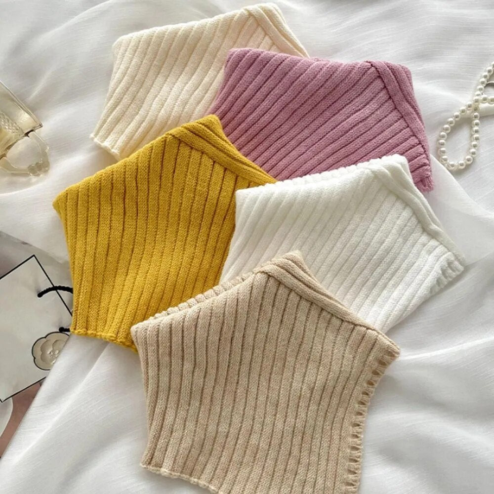 Sechs gestrickte, gerippte Halswärmer in Gelb, Rosa, Beige und Weiß auf weißem Hintergrund.