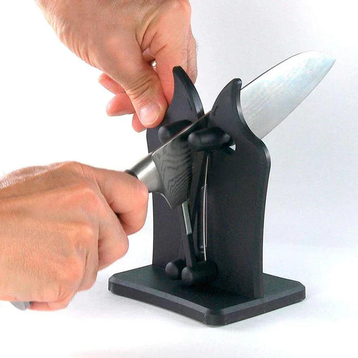 Person schleift Messer mit schwarzem Messerschärfer, Edelstahlklinge, Küchengerät.
