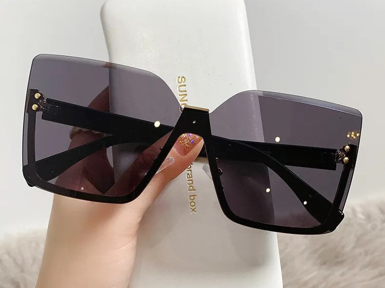 Schwarze übergroße Sonnenbrille mit eckigen Gläsern, modisch, UV-Schutz, Damenaccessoire.