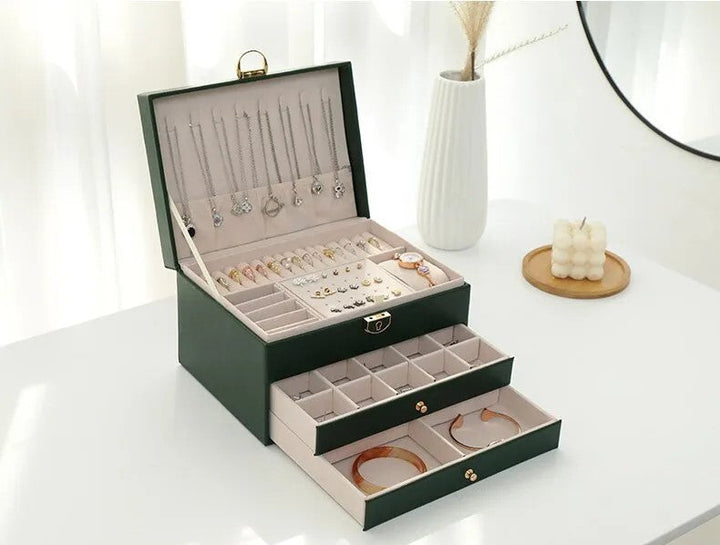 Grüne Schmuckschatulle mit Fächern, Ketten und Ringen, elegantes Design, Schmuckaufbewahrung.