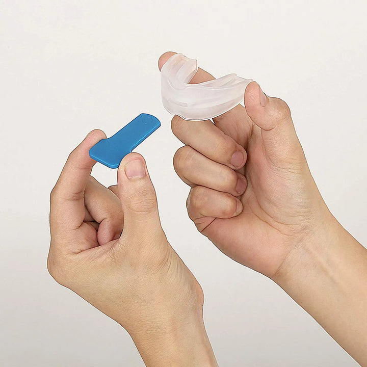 Hände halten blauen Nasenclip und transparenten Nasendilatator aus Silikon.