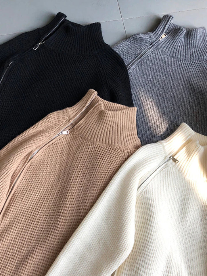 Vier Rollkragenpullover in Schwarz, Grau, Beige und Weiß, aus Strick, mit Reißverschluss.