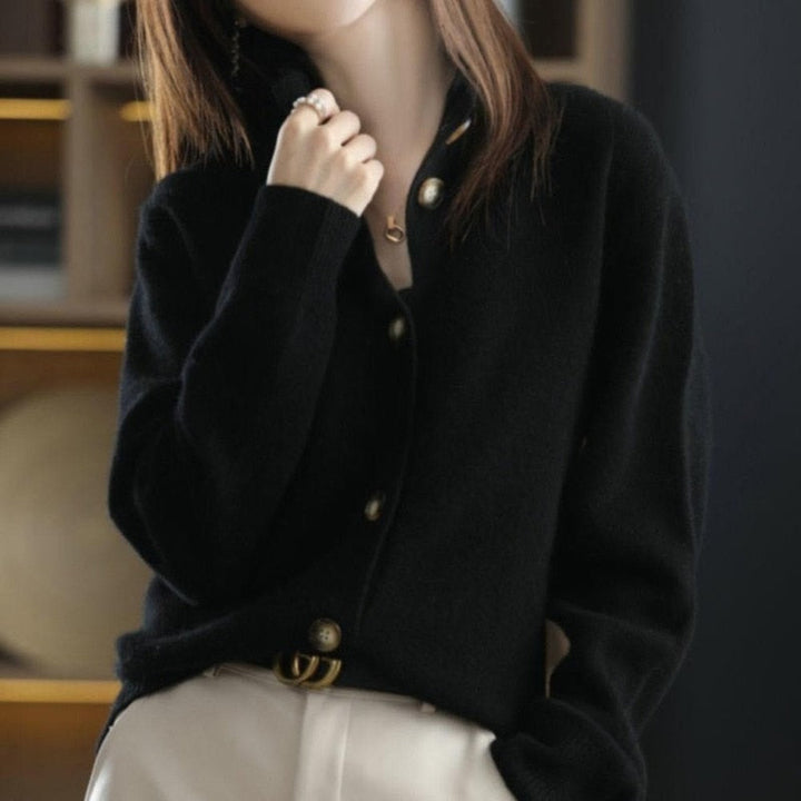 Frau trägt schwarzen Kaschmir-Cardigan mit goldenen Knöpfen, elegantes Design, Herbstmode.