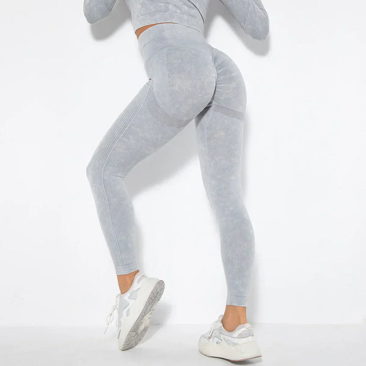 Frau in grauer Sportleggings und Sneakers, Fitnessmode, nahtlos, elastisch, für Workout.