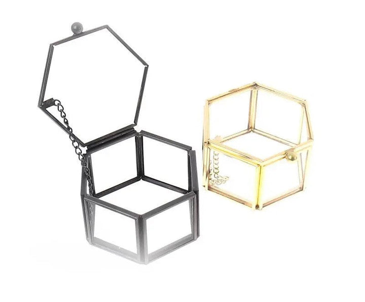 Schwarze und goldene sechseckige Schmuckboxen aus Metall, offen, modern, stilvoll.