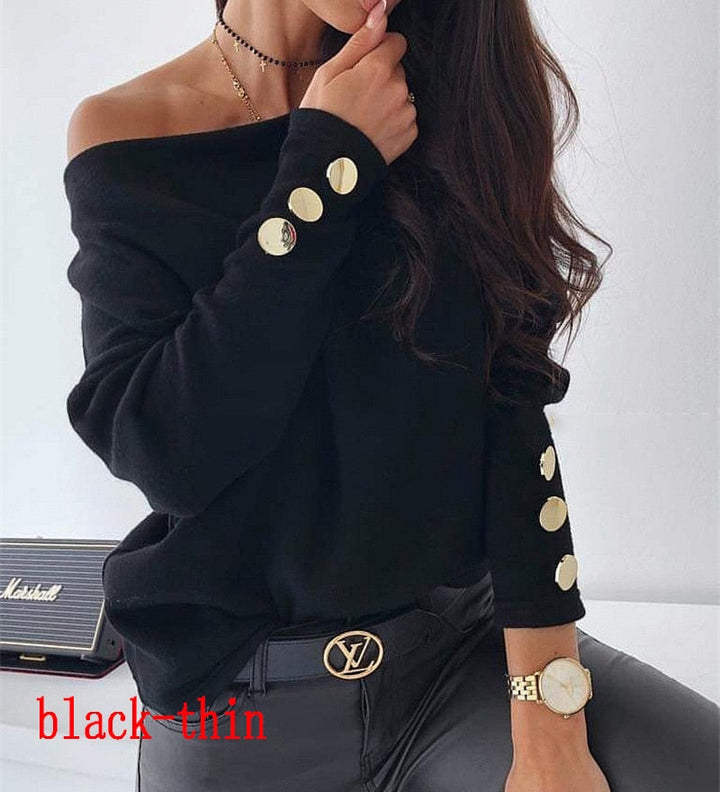 Frau in schwarzem Pullover mit goldenen Knöpfen, schulterfrei, modisch, elegant.