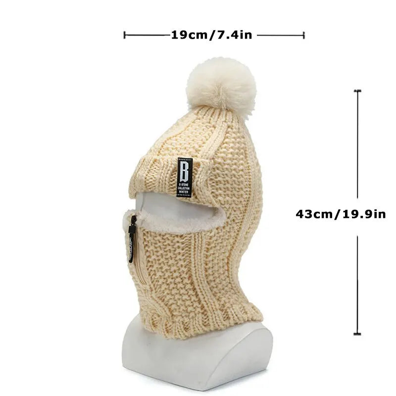 Beige gestrickte Sturmhaube mit Bommel, Reißverschluss und Etikett, 43cm hoch, 19cm breit.