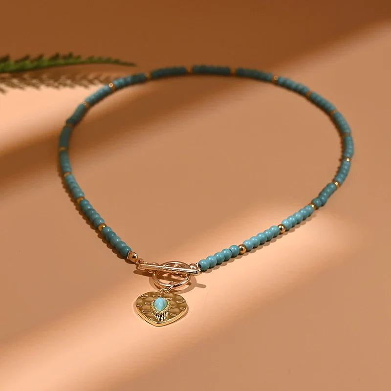 Türkisfarbene Perlenkette mit goldfarbenem Herzanhänger, eleganter Schmuck für Damen.