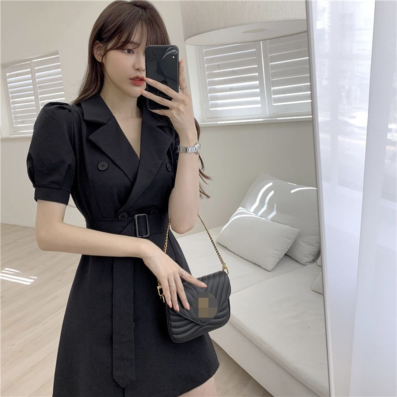Frau in schwarzem Wickelkleid mit Handtasche, Selfie, modernes Wohnzimmer, Tageslicht.